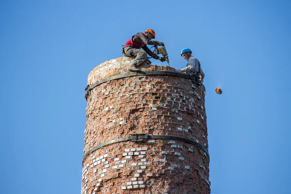 Alpiniști industriali pe un coș de cărămidă